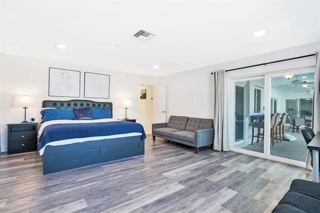 a bedroom with a bed and wooden floor