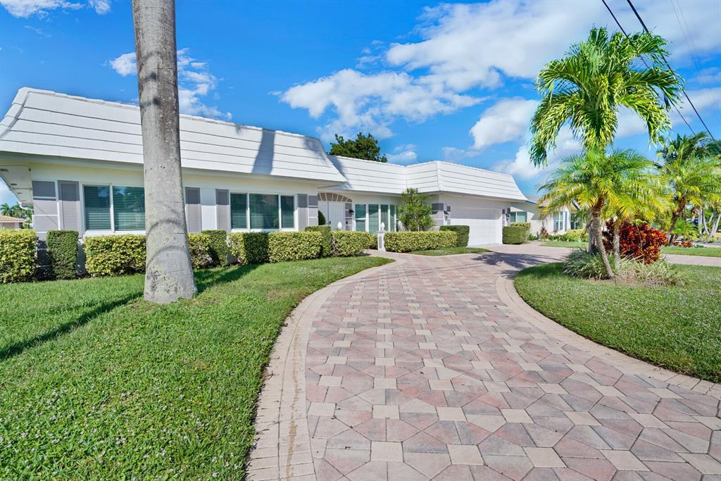4101 Northeast 24th Avenue Lighthouse Point, FL 33064 - Photo 2 of 30 a front view of a house with a garden and plants