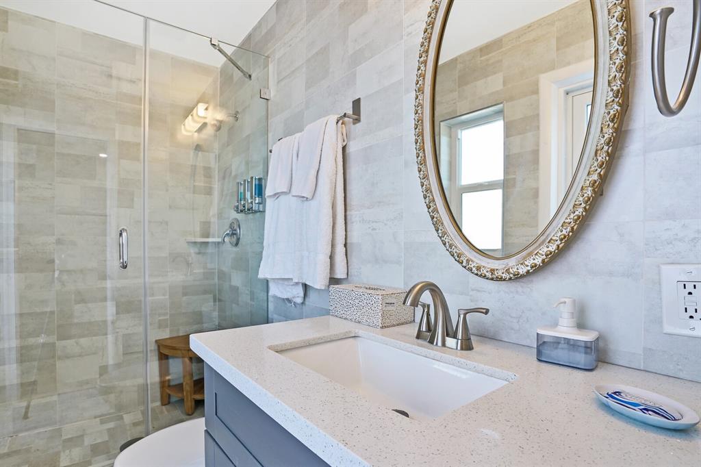 4101 Northeast 24th Avenue Lighthouse Point, FL 33064 - Photo 22 of 30 a bathroom with a sink a mirror a vanity and a shower