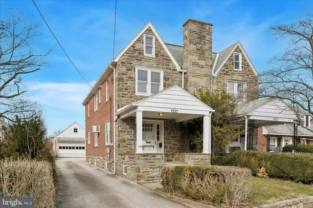 a view of a white house with large windows and a small yard