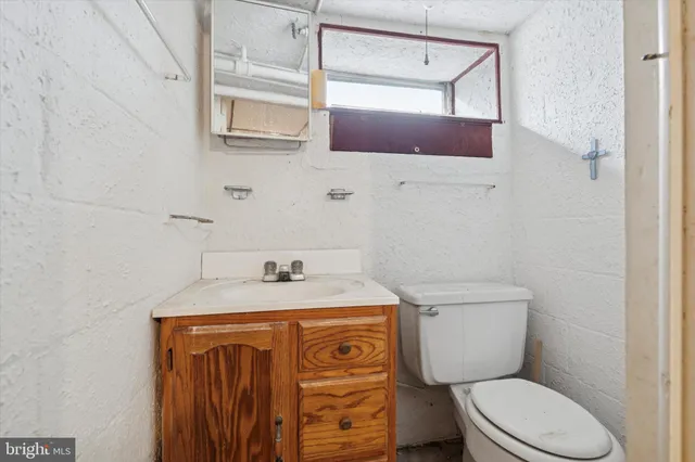 a bathroom with a granite countertop toilet sink and mirror
