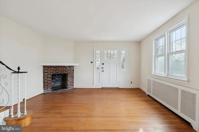 a view of an empty room with a fireplace and a window