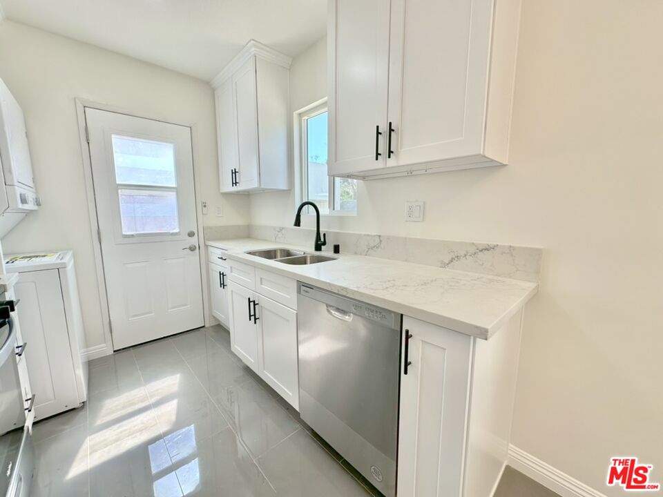 10720 Charnock Road Los Angeles, CA 90034 - Photo 24 of 33 a utility room with sink dryer and cabinets