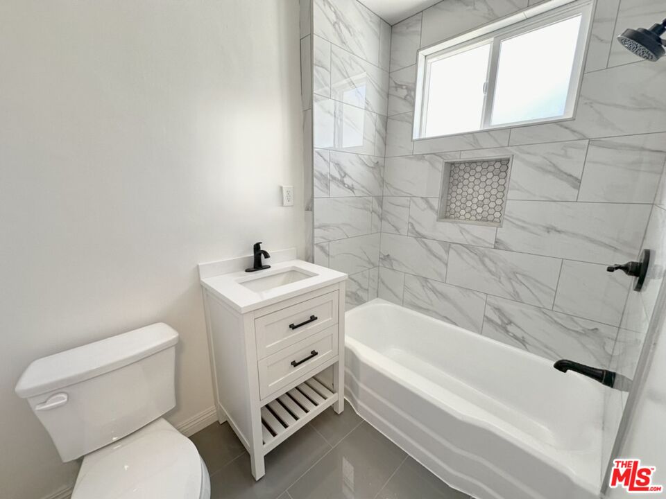 10720 Charnock Road Los Angeles, CA 90034 - Photo 25 of 33 a bathroom with a toilet a sink a mirror and bathtub