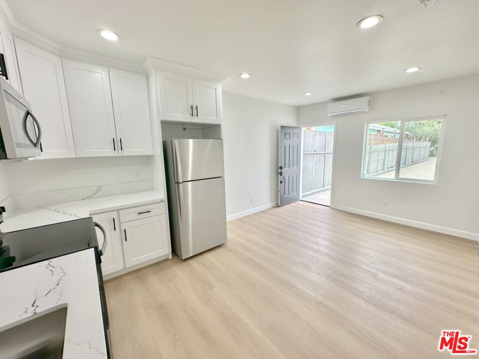 10720 Charnock Road Los Angeles, CA 90034 - Photo 26 of 33 a kitchen with a refrigerator a stove top oven and white cabinets