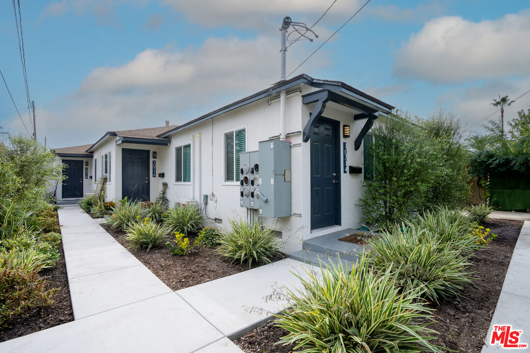 10720 Charnock Road Los Angeles, CA 90034 - Photo 4 of 33 a front view of house with a yard and potted plants
