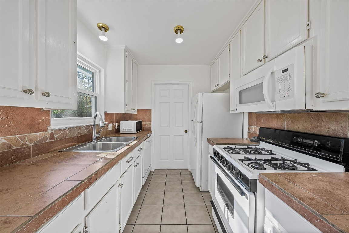 3007 Steck Avenue Austin, TX 78757 - Photo 6 of 15 a kitchen with granite countertop a sink stove and cabinets