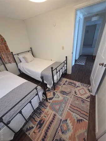 a bed sitting in a bedroom next to a window with a dresser