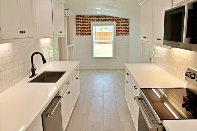 a kitchen with a sink a stove and cabinets