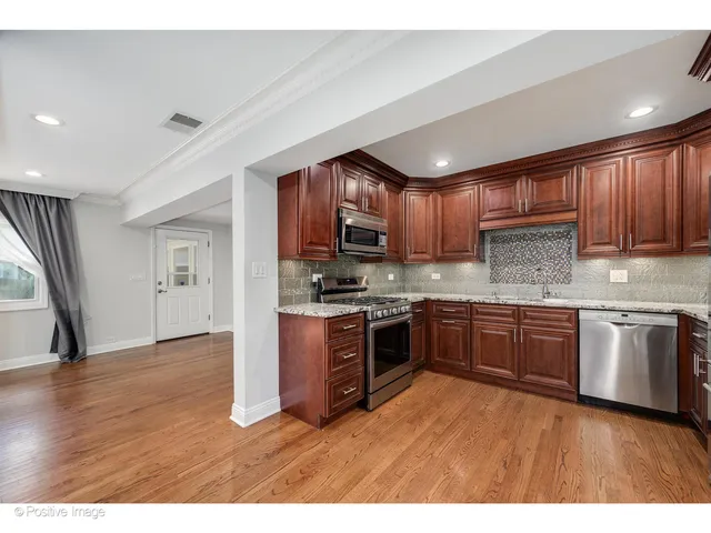 a kitchen with stainless steel appliances granite countertop wooden cabinets a stove a sink and dishwasher