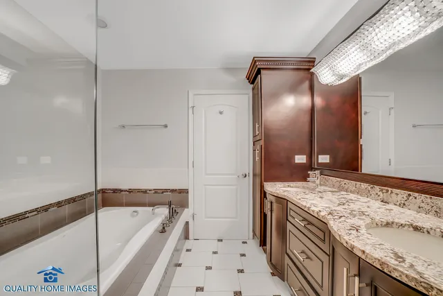 a bathroom with a granite countertop sink and a bathtub