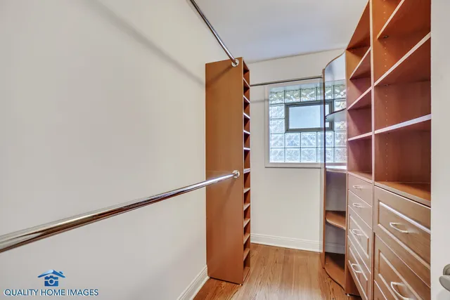 a view of walk in closet with wooden floor