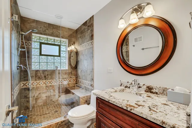 a bathroom with a sink a toilet and a mirror