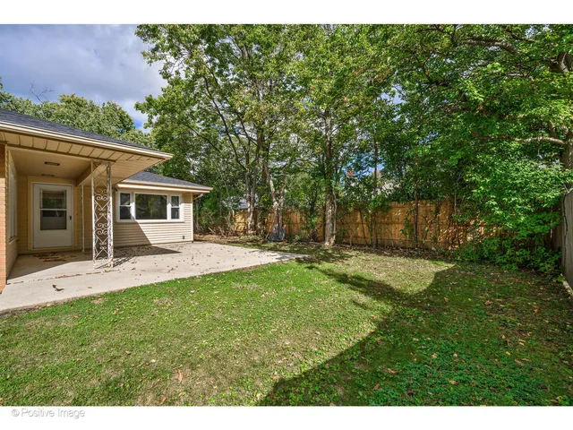 a front view of a house with a yard and potted plants
