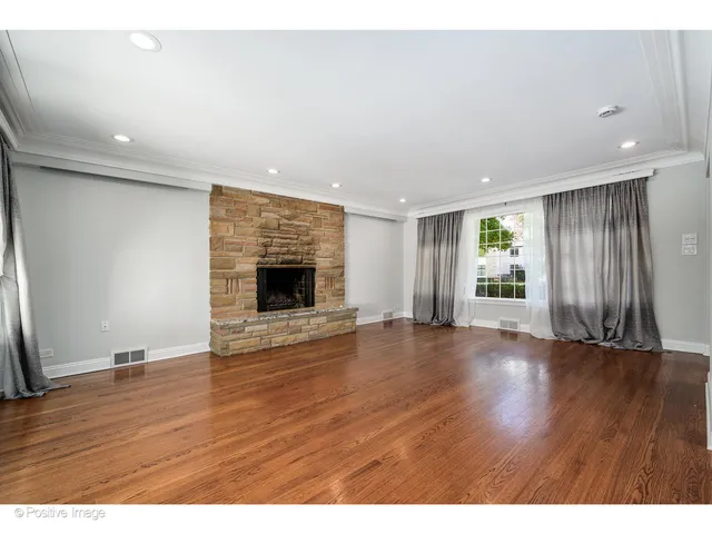 an empty room with wooden floor and fireplace