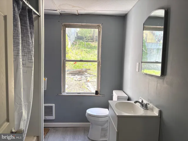 a bathroom with a toilet sink and mirror
