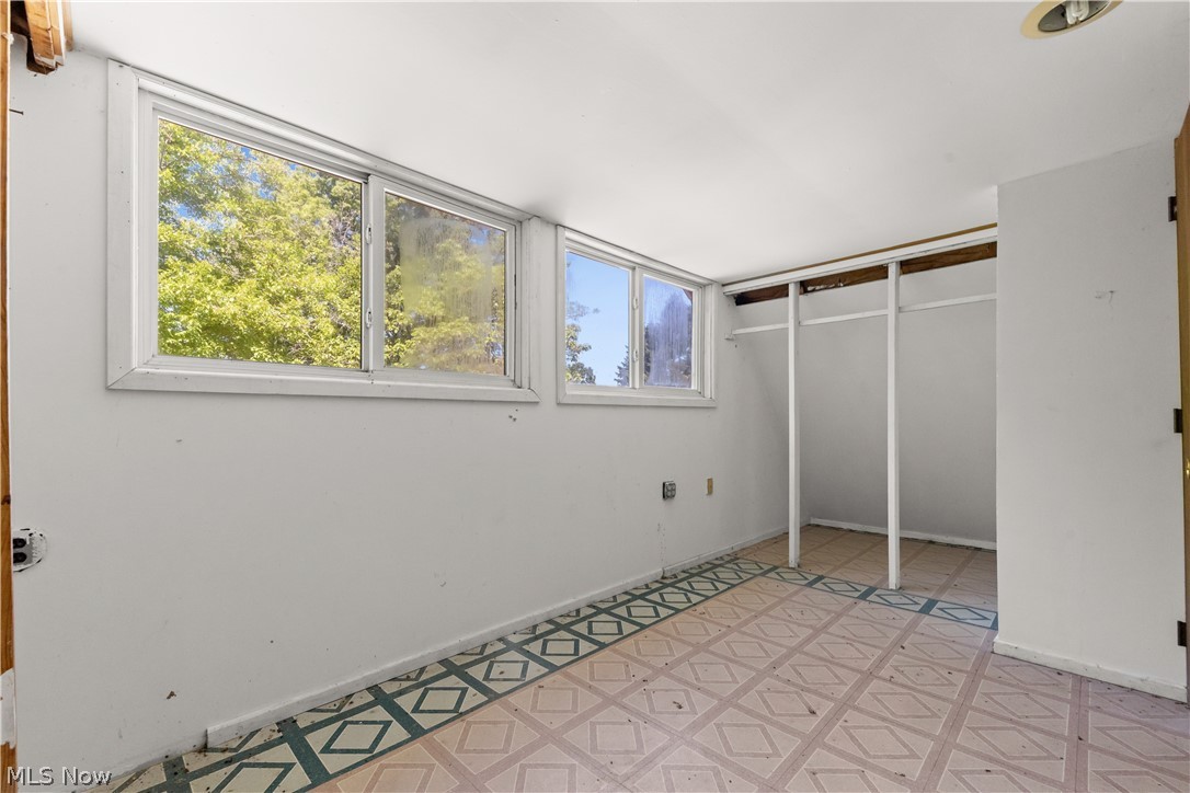 409 Edith Avenue Akron, OH 44312 - Photo 18 of 45 Room featuring light-colored walls, multiple windows with white trim, and a patterned floor