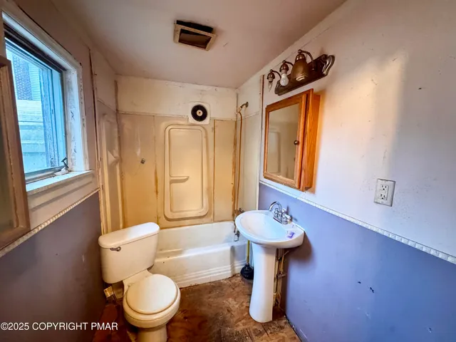 a bathroom with a toilet a sink and a window