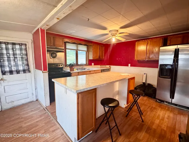 a kitchen with stainless steel appliances granite countertop a refrigerator and a stove top oven