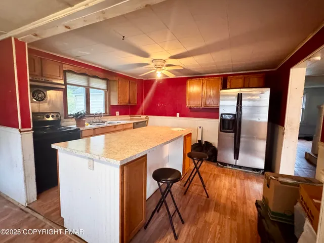 a view of a kitchen with stainless steel appliances granite countertop a stove and a refrigerator