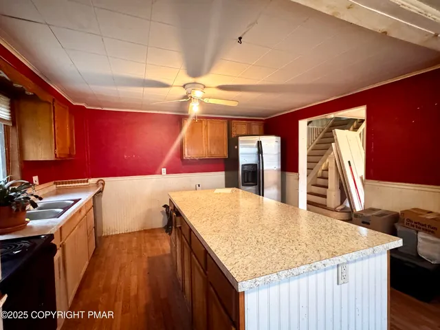 a kitchen with stainless steel appliances granite countertop a sink dishwasher and wooden cabinets with a large window