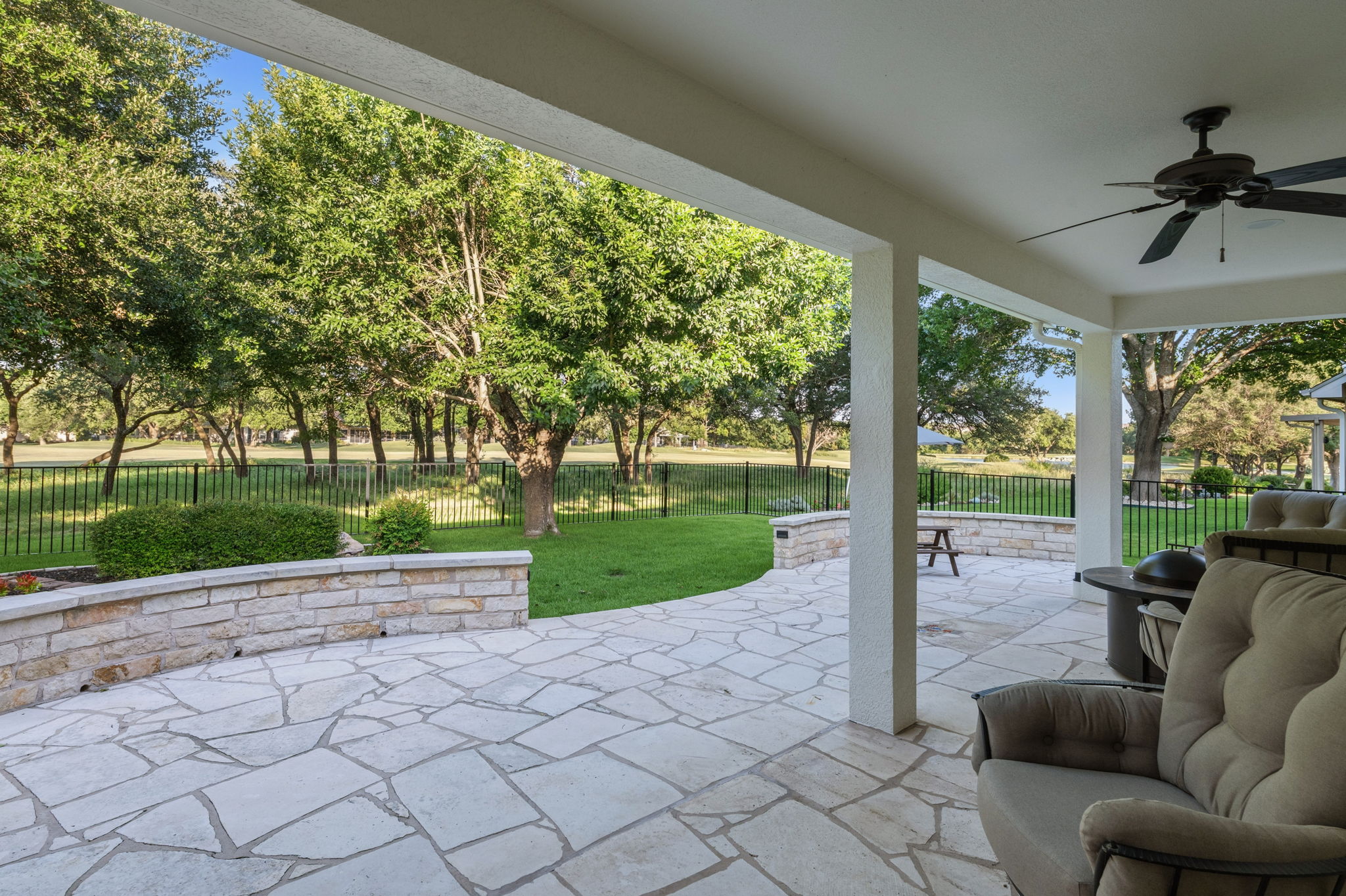118 Cold Springs Drive Georgetown, TX 78633 - Photo 37 of 40 An inviting covered patio featuring flagstone flooring overlooks a verdant lawn and mature trees.