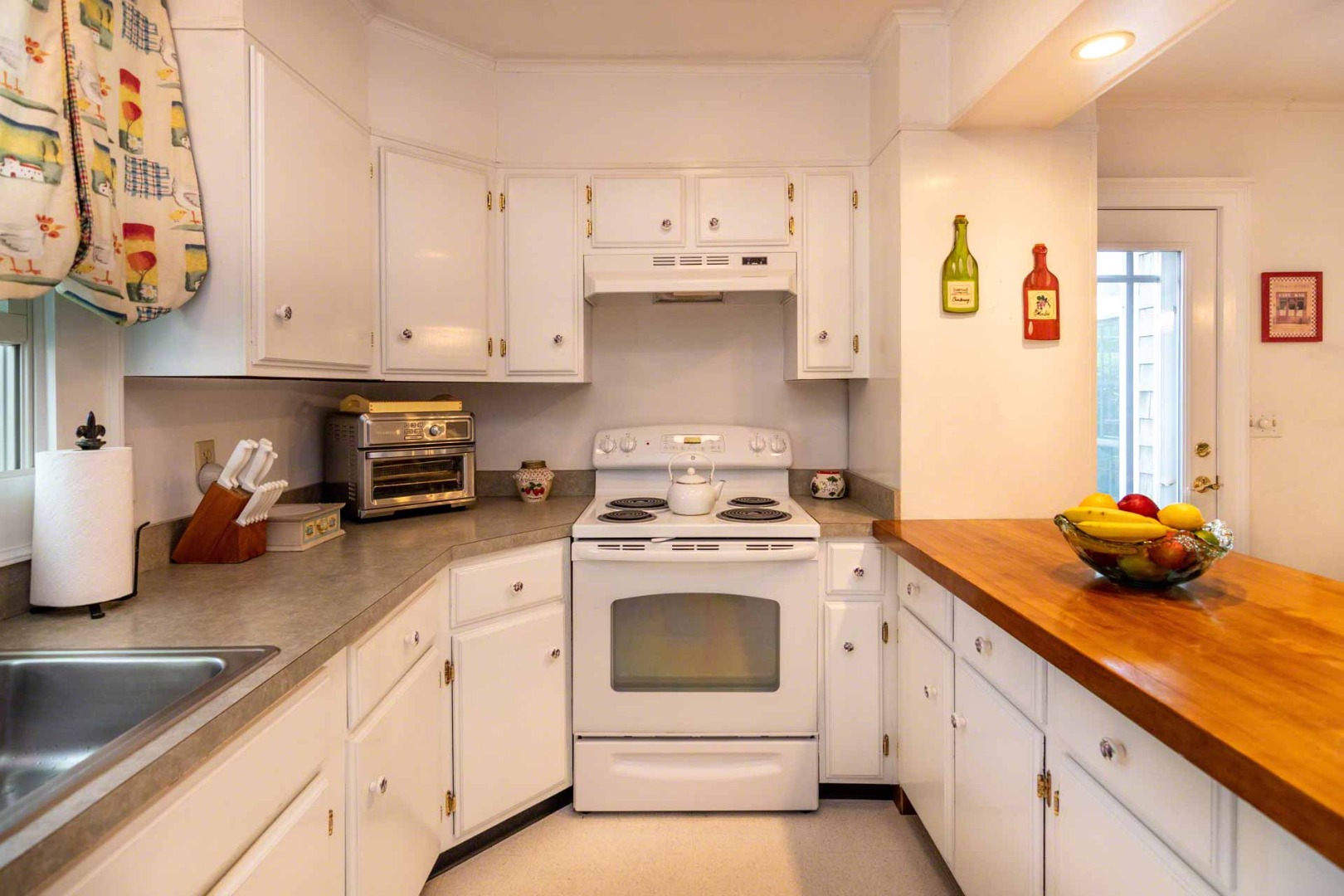 25 High Street Edgartown, MA 02539 - Photo 11 of 26 a kitchen with cabinets appliances a sink and a counter top space
