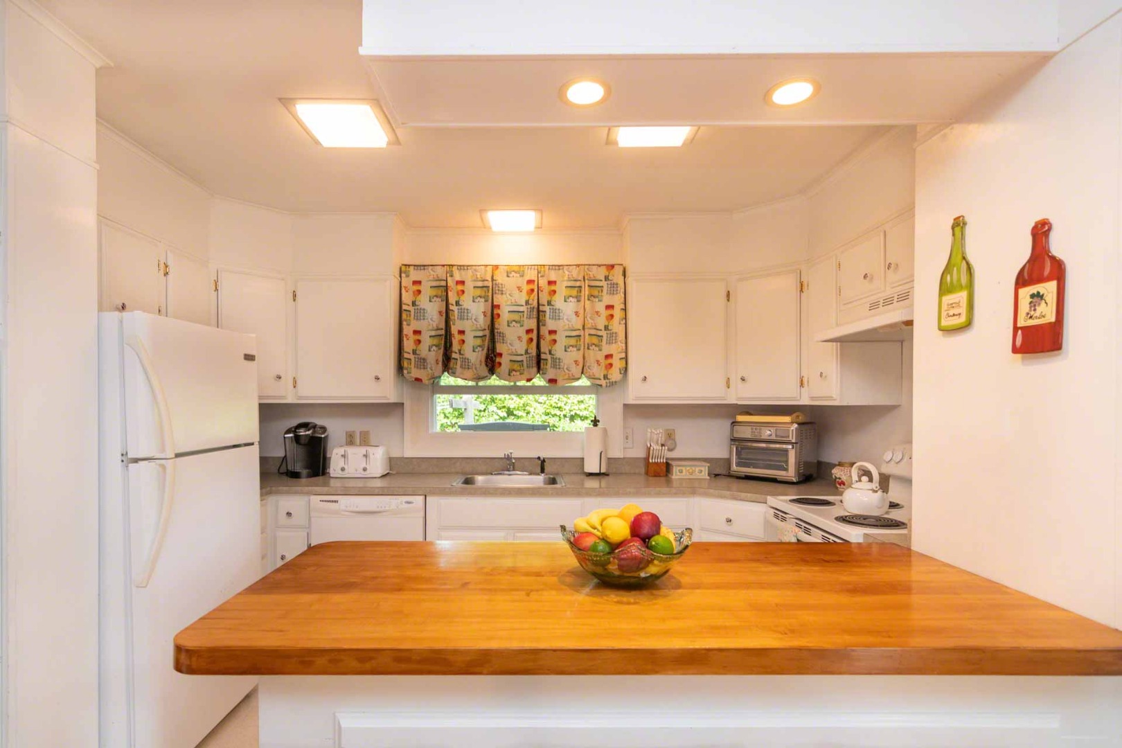 25 High Street Edgartown, MA 02539 - Photo 12 of 26 a kitchen with a refrigerator a stove a sink dishwasher with a dining table and chairs