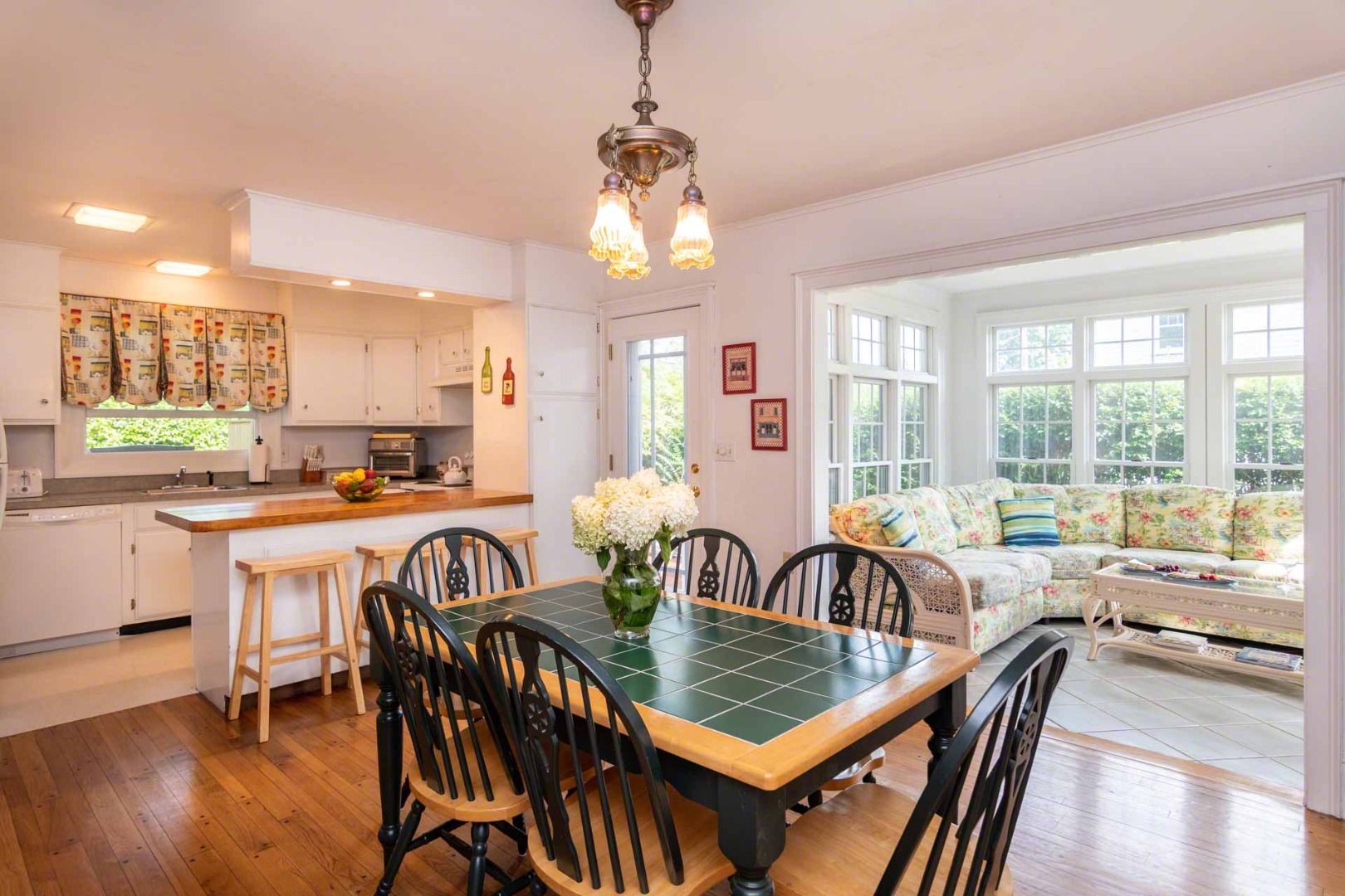 25 High Street Edgartown, MA 02539 - Photo 8 of 26 a view of a dining room and livingroom with furniture wooden floor a chandelier