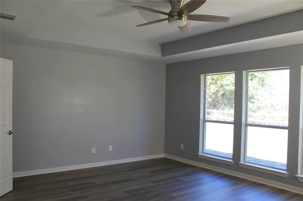 3051 Plainview Road Midlothian, TX 76065 - Photo 3 of 19 an empty room with wooden floor fan and windows