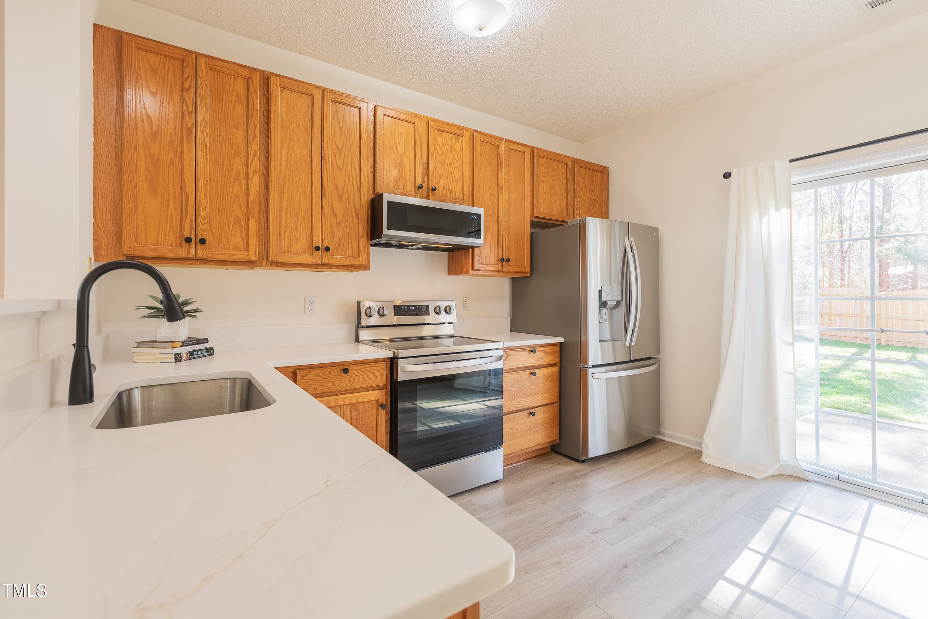 10809 Farmville Road Raleigh, NC 27614 - Photo 12 of 28 a kitchen with stainless steel appliances granite countertop a refrigerator stove and sink