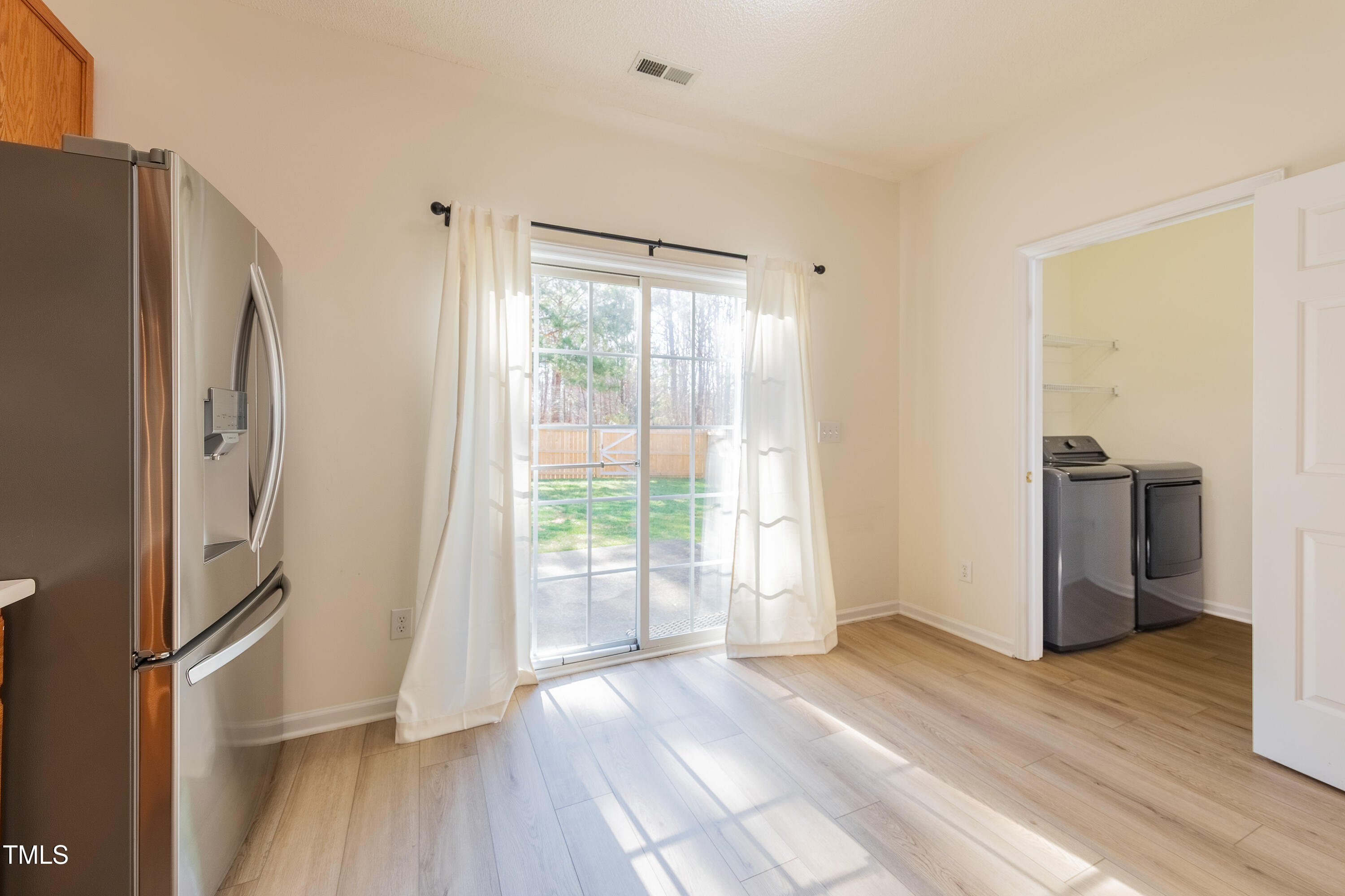10809 Farmville Road Raleigh, NC 27614 - Photo 15 of 28 a view of a kitchen with a refrigerator wooden floor and a window