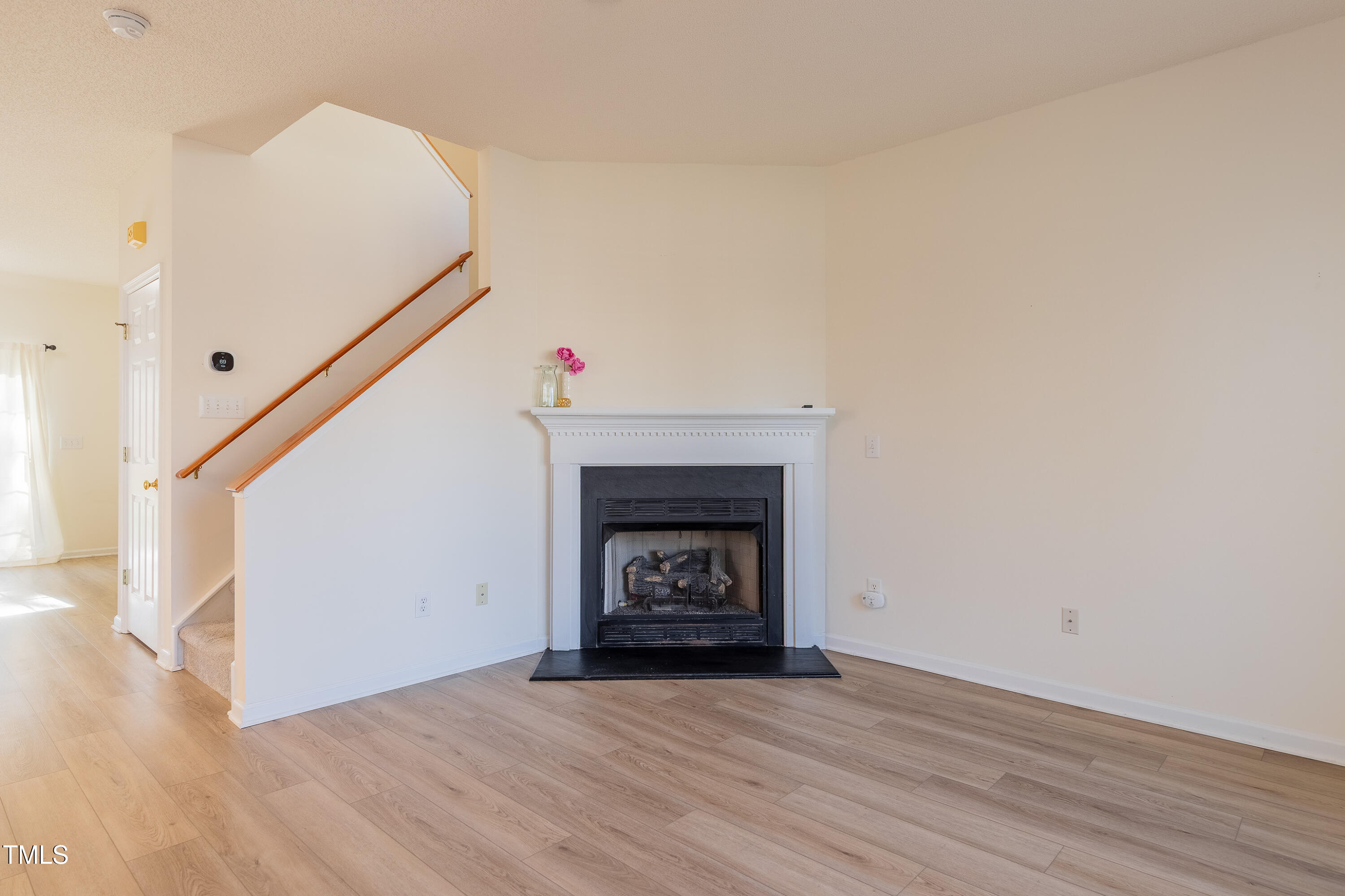 10809 Farmville Road Raleigh, NC 27614 - Photo 5 of 28 a view of an empty room with wooden floor and a fireplace