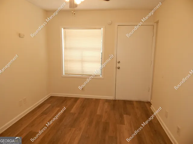 an empty room with wooden floor and a window