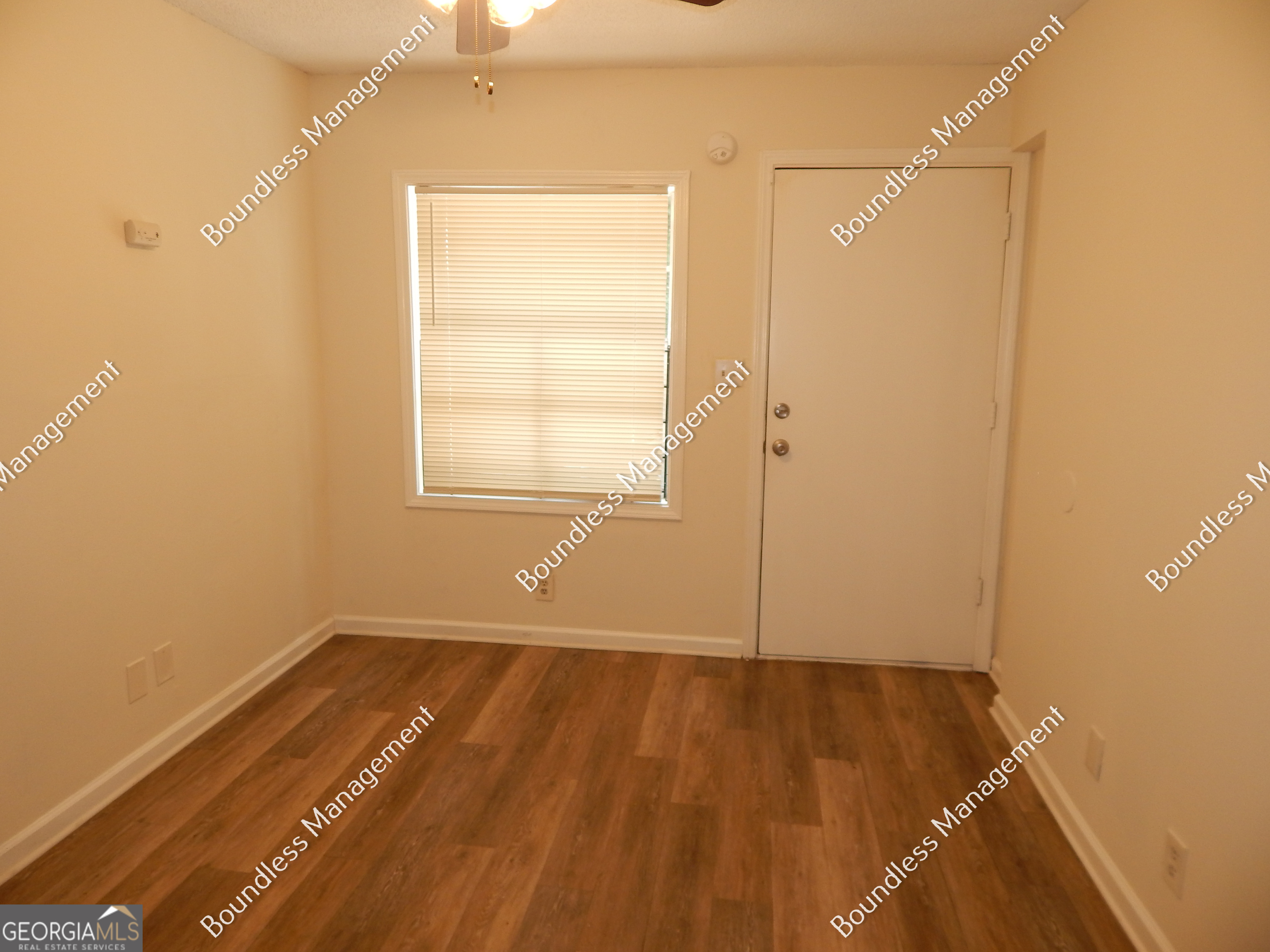 3627 Forrest Park Road Southeast, Unit 25 Atlanta, GA 30354 - Photo 2 of 13 an empty room with wooden floor and a window