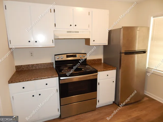 a kitchen with granite countertop white cabinets and a sink