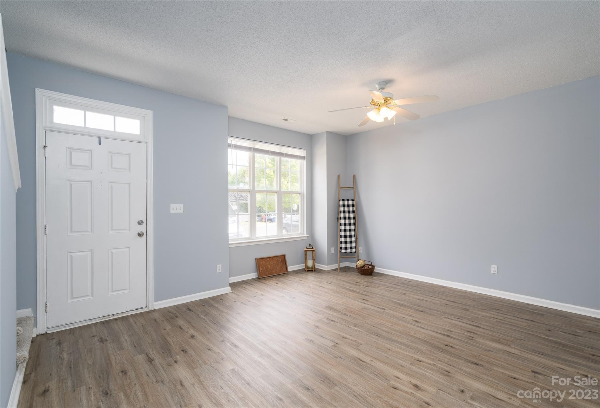 5908 Britt Lane Dallas, NC 28034 - Photo 3 of 22 an empty room with wooden floor chandelier fan and windows