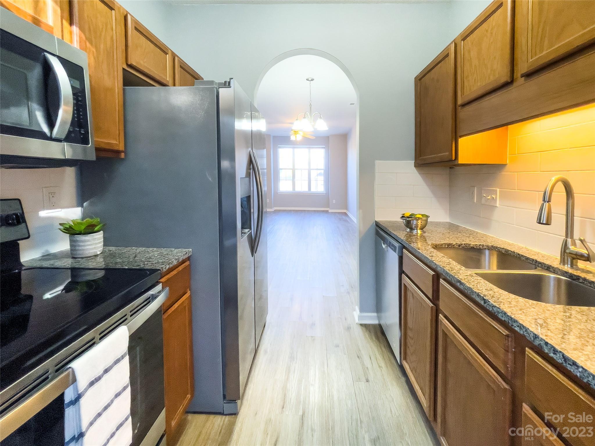 5908 Britt Lane Dallas, NC 28034 - Photo 6 of 22 a kitchen with stainless steel appliances granite countertop a sink a stove wooden cabinets and entryway
