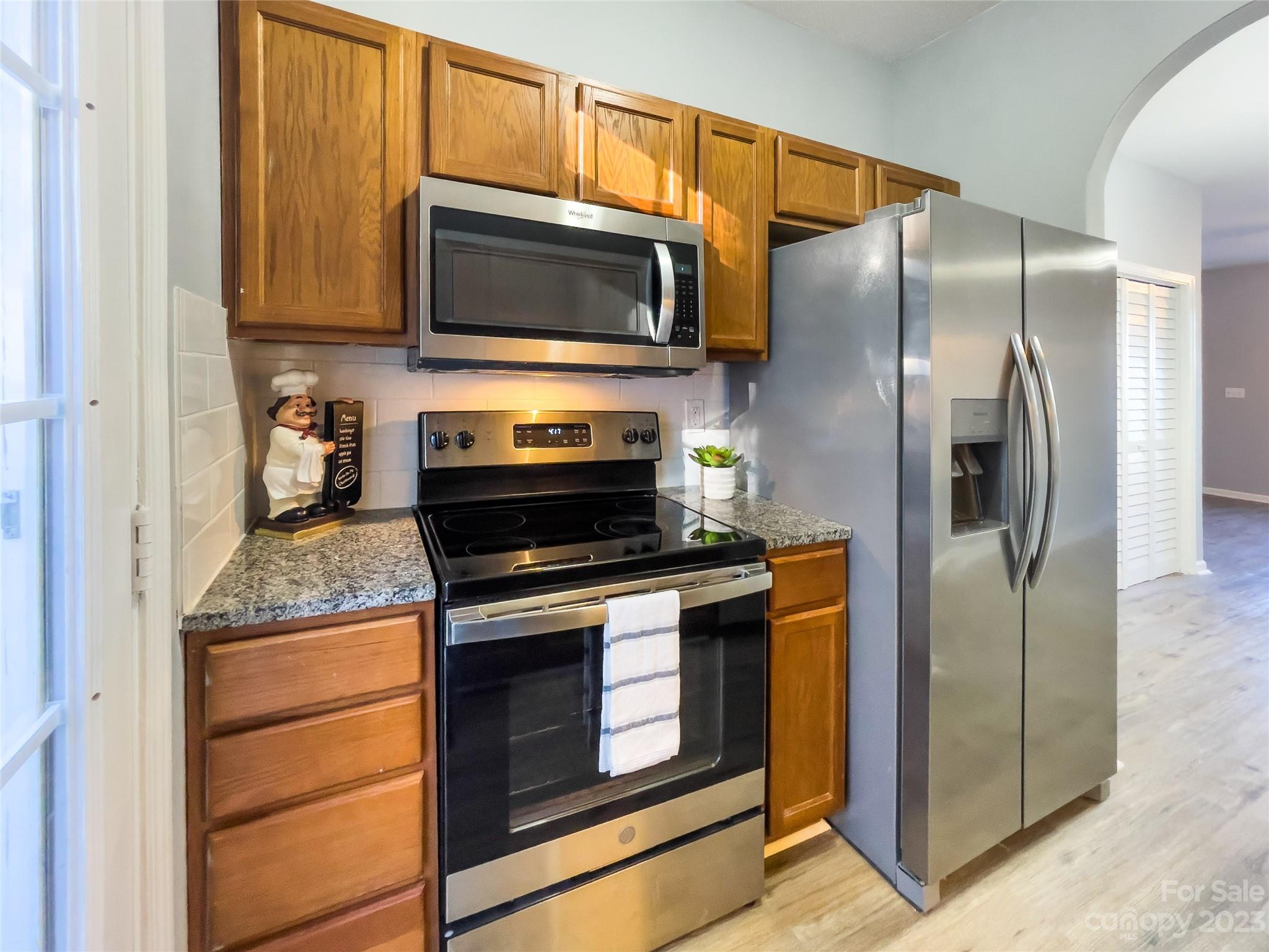 5908 Britt Lane Dallas, NC 28034 - Photo 7 of 22 a kitchen with granite countertop a refrigerator stove and microwave