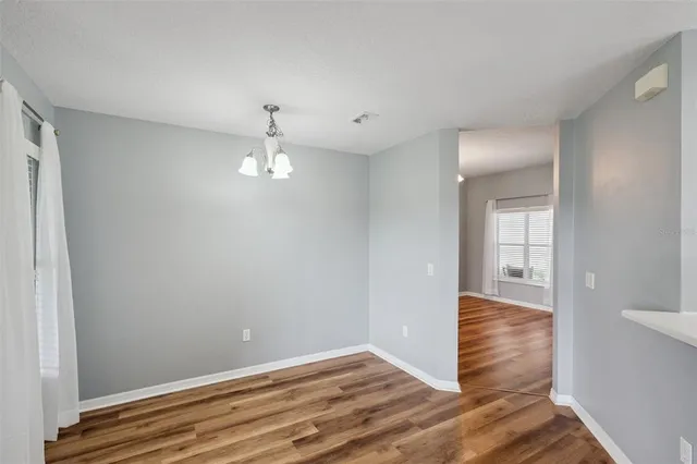 a view of empty room with wooden floor and ceiling fan