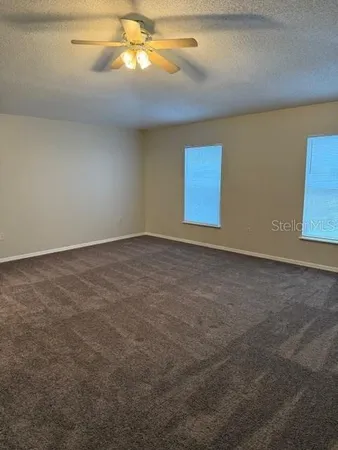 en empty room with windows and fan