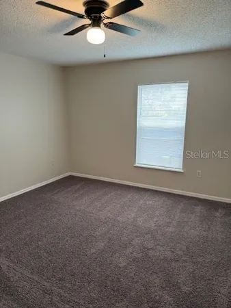 an empty room with a chandelier fan