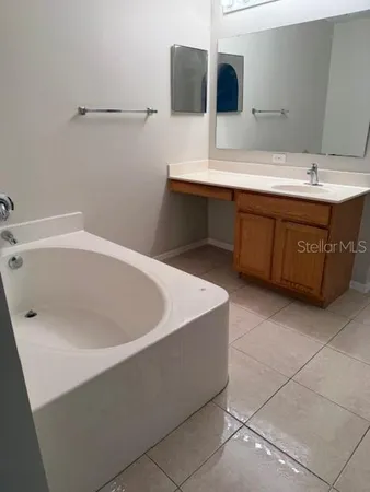 a bathroom with a tub sink and mirror