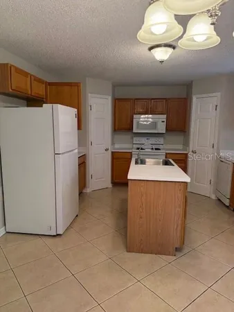 a kitchen with stainless steel appliances granite countertop a refrigerator a stove a sink and dishwasher