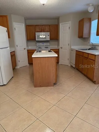 a kitchen with stainless steel appliances a stove a sink a counter top space and cabinets
