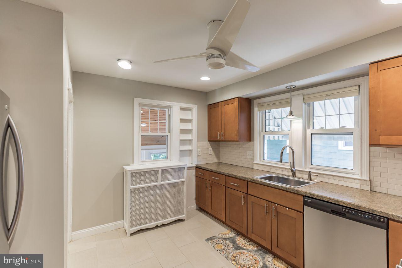204 Princeton Road Audubon, NJ 08106 - Photo 5 of 22 a large white kitchen with a sink and dishwasher next to a large window