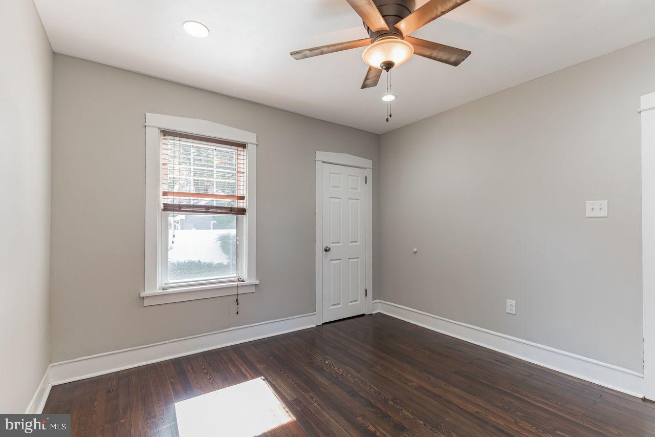 204 Princeton Road Audubon, NJ 08106 - Photo 9 of 22 an empty room with wooden floor chandelier fan and windows