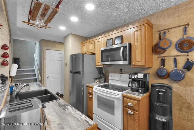 a kitchen with stainless steel appliances granite countertop a stove a refrigerator and a microwave