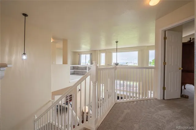 a view of a hallway with windows and stairs