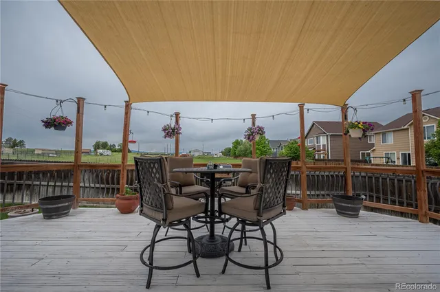 a view of a roof deck with table and chairs potted plants with wooden floor